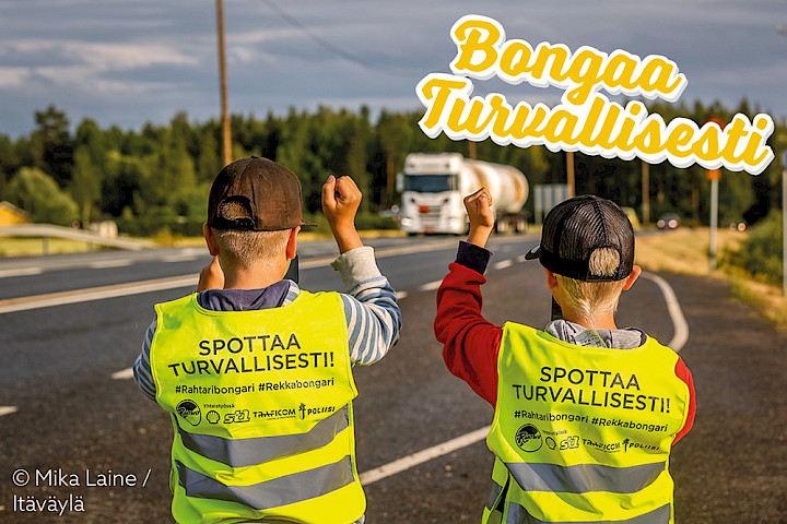 Bongarit tervehtivät kuorma-autoa Bongaa turvallisesti -huomioliiveissä.